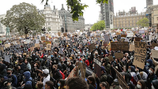 People hold placards during a Black Lives Matter rally in Parliament Square in London, Saturday, June 6, 2020