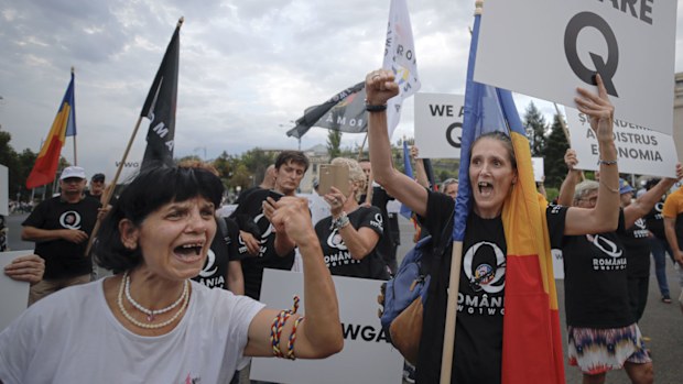 Romanian supporters of QAnon shout slogans against the government's measures to prevent the spread of COVID-19 infections.