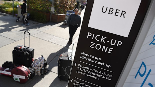 Travellers wait at the new designated pick-up zone for Uber at Tullamarine Airport in Melbourne installed in August this year.