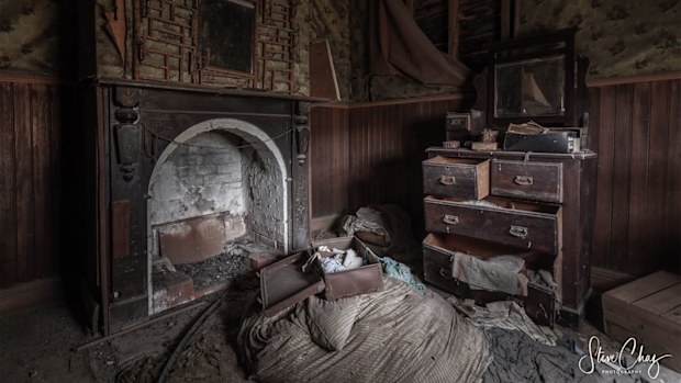 A half-packed suitcase sits on top of what appears to be some bedding.