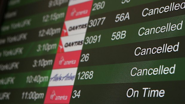 Cancelled flights due to weather are displayed on a departure monitor at San Francisco International Airport