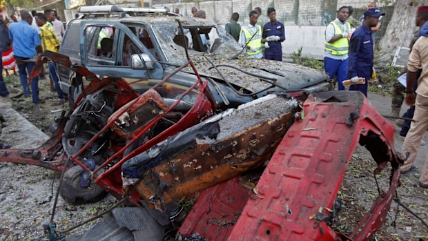Rescue workers stand near the wreckage of vehicles in Mogadishu, Somalia, after a car bomb was detonated Saturday night (AP Photo/Farah Abdi Warsameh)