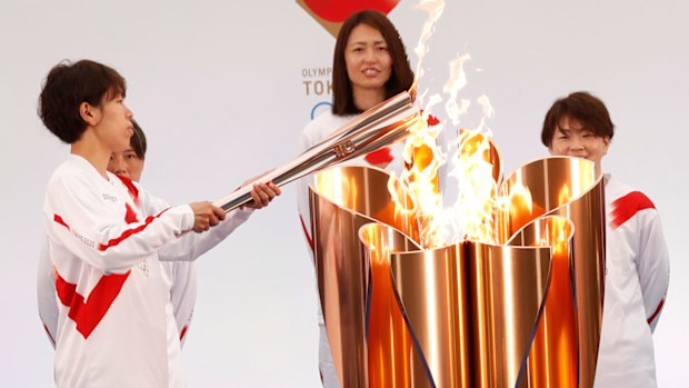 Japanese torchbearer Azusa Iwashimizu (C), a member of Japan women's national football team, arrives at a torch kiss point to pass on the flame. (Getty)