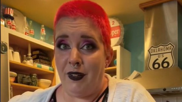 Mum with short red hair and intense makeup.