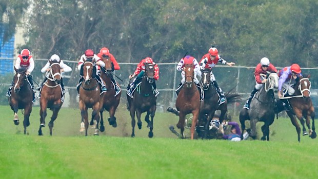 Jockey Andrew Adkins crashes to the turf during the opening race at Rosehill.