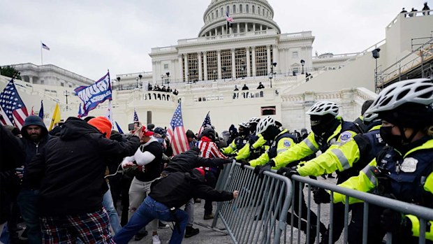 Trump supporters try to break through a police barrier.