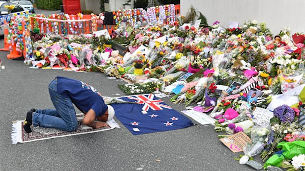 A muslim worshipper prays at a makeshift memorial near the Al Noor Mosque on Deans Rd in Christchurch.