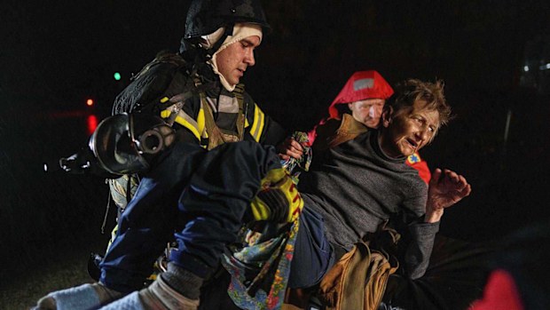 Rescuers carry an injured woman into an ambulance after a Russian strike on a residential neighborhood in Kyiv.