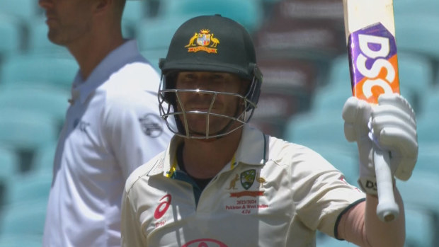 David Warner raises the bat after notching up a fifty in his final Test innings.