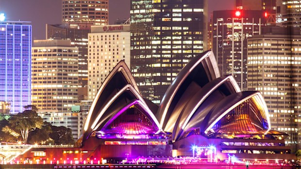 The Sydney Opera House and Sydney's skyline at night.