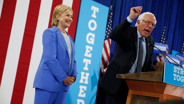 Democratic presidential candidate Hillary Clinton listens as Sen.Bernie Sanders endorses her at a rally in New Hampshire. (AAP)