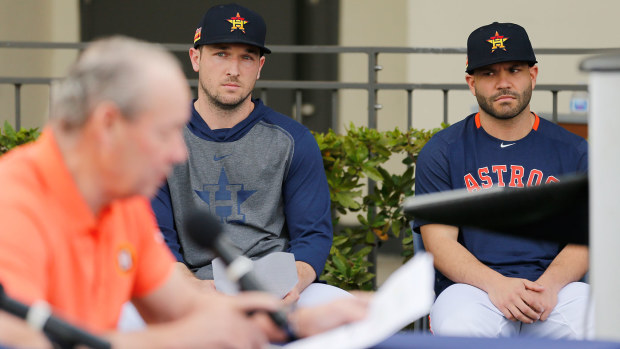 Alex Bregman #2 and Jose Altuve #27 of the Houston Astros look on as owner Jim Crane reads a prepared statement