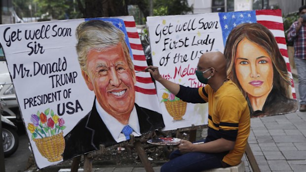 An artist from Gurukul art school paints a poster carrying a message for US President Donald Trump and first lady Melania in Mumbai, India.