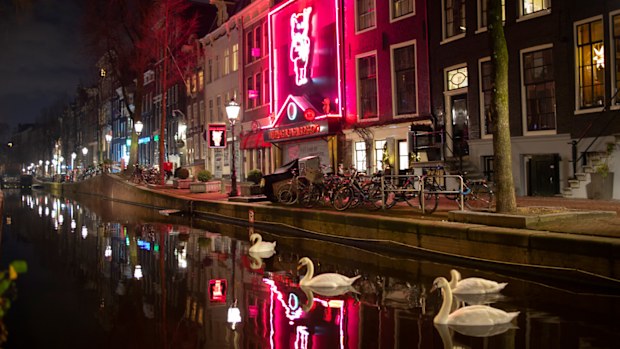 Apart from a few swans Amsterdam Red Light District, with the Casa Rosso erotic theatre, center, is deserted in Amsterdam.