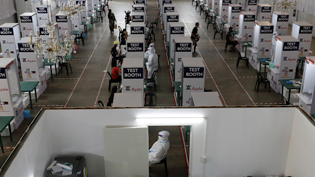 Health workers perform testing at a COVID-19 testing center at the Palacio de Manila during an enhanced community quarantine to prevent the spread of the new coronavirus on Monday, May 11, 2020. (AP Photo/Aaron Favila)