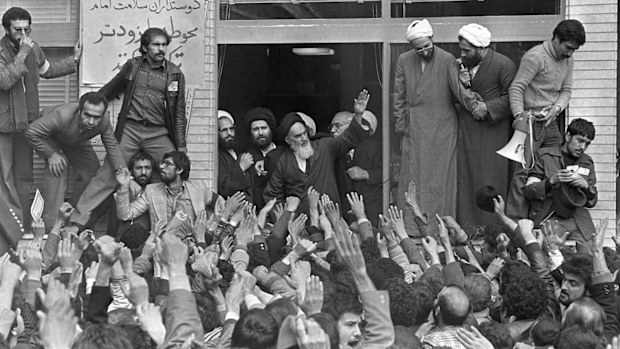 Ayatollah Ruhollah Khomeini, center, waves to followers as he appears on the balcony of his headquarters in Tehran in 1979.
