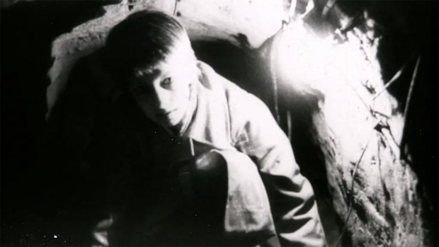 A young woman crawling through the tunnel to freedom.