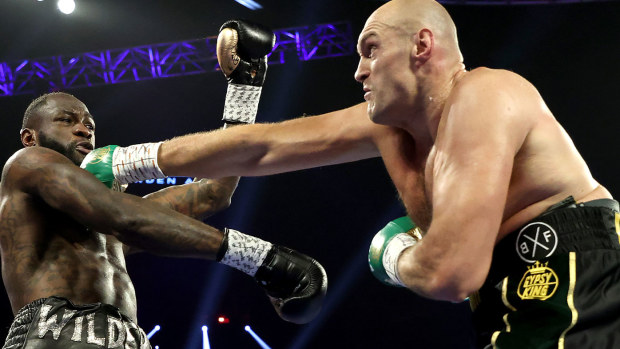 Tyson Fury (R) punches Deontay Wilder during their Heavyweight bout for Wilder's WBC and Fury's lineal heavyweight title