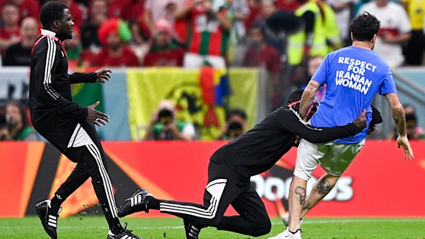 Security tackles a pitch invader during the Portugal-Uruguay match.