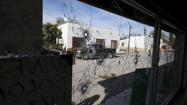A shop's windows are riddled with bullets near City Hall.