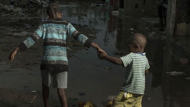 Children walk through the flooded streets of the city of Beira, Sofala Province, Mozambique, after Cyclone Idai made land fall.