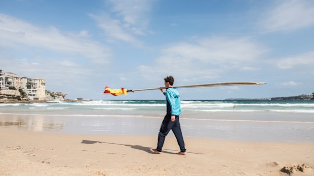 A lifeguard removes a flag.