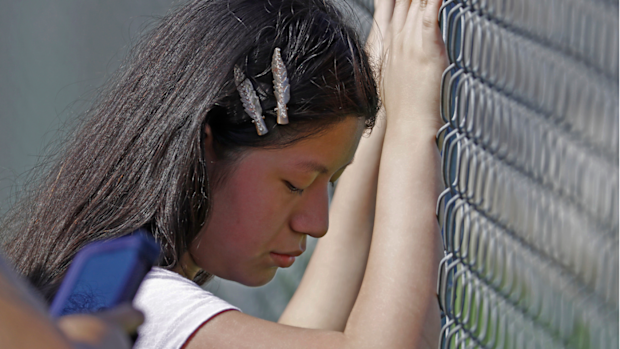 This young woman cries while standing outside the Koch Foods Inc., plant as U.S. immigration officials raid the plant in Morton.