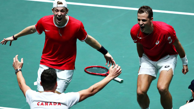 Vasek Pospisil and Denis Shapovalov celebrate with Canada team captain Frank Dancevic after winning