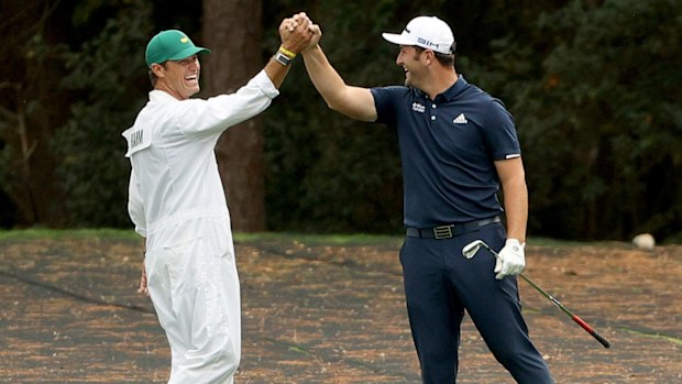 Jon Rahm of Spain celebrates with his Adam Hayes after skipping in for a hole in one on the 16th