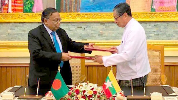 Myanmar's Union Minister for the Office of the State Counsellor Kyaw Tint Swe (right) and Bangladesh Foreign Minister Abdul Hassan Mahmud Ali exchange notes after signing the Arrangement on Return of Displaced Persons from Rakhine State in Naypyitaw, Myanmar. (AAP)