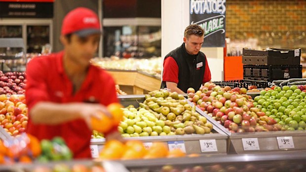 Coles staff restock shelves ahead of opening time.