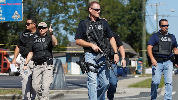 Heavily-armed law enforcement agents patrol the crime scene after the latest killing in a Florida suburb on Tuesday. (Photo: AP).