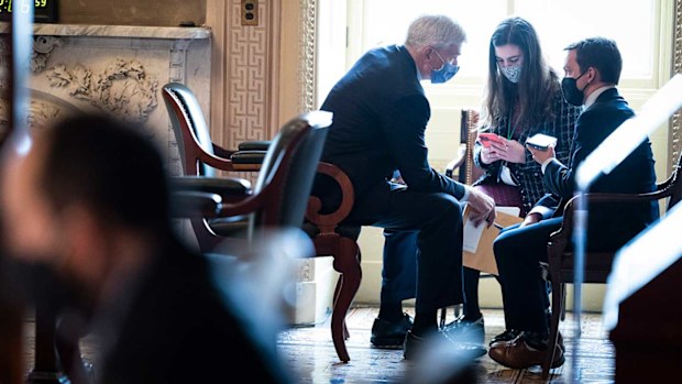 Bill Cassidy confers with staffers outside the chamber.