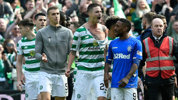 Celtic's Mikael Lustig with his shirt torn remonstrates with Rangers Jermain Defoe