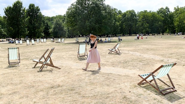 A woman walks in Green Park in London as the country endures a potentially record-breaking heatwave. (AAP)