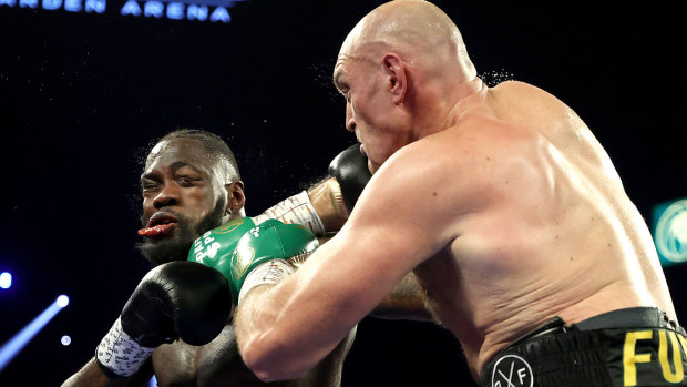 Tyson Fury (R) punches Deontay Wilder during their Heavyweight bout for Wilder's WBC and Fury's lineal heavyweight title 