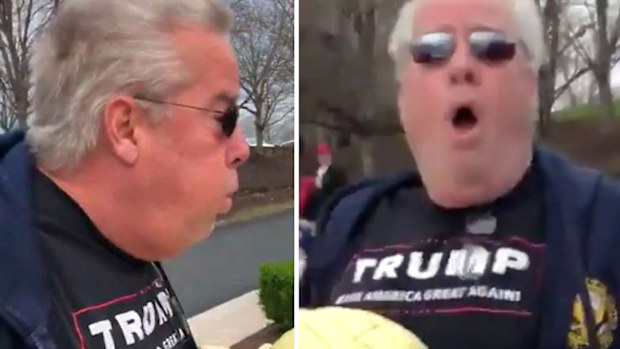 A man who deliberately breathed heavily on two protesters outside of President Donald Trump's golf course in Virginia has been charged with assault