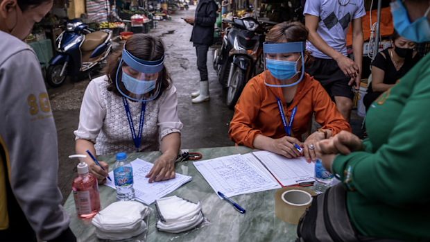 HANOI, VIETNAM - APRIL 18: Market staff wear face shields while taking information from vendors and labourers at Long Bien market for coronavirus disease (COVID-19) rapid test on April 18, 2020 in Hanoi, Vietnam. 