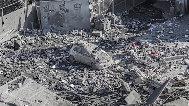 A destroyed car among the rubble of a building damaged after an Israeli airstrike in Gaza.