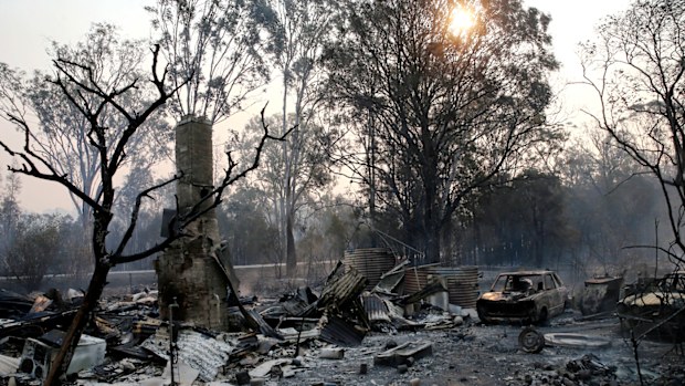 The ruins of a house smoulders on Old Bar road Near Taree, NSW