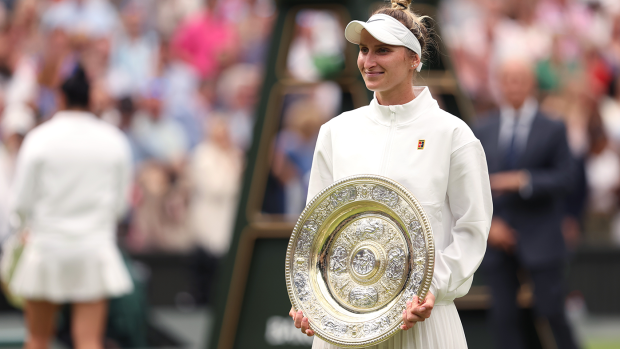 Marketa Vondrousova smiles with Wimbledon's women's singles trophy following her victory over Ons Jabeur in the final.
