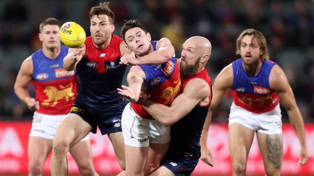 Lachie Neale of the Lions handpasses the ball away from Max Gawn of the Demons during the 2021 AFL First Qualifying Final match between the Melbourne Demons and the Brisbane Lions at Adelaide Oval on August 28, 2021 in Adelaide, Australia. (Photo by Sarah Reed/AFL Photos via Getty Images)