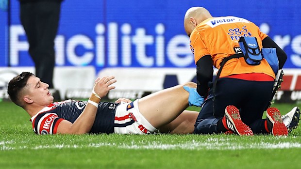 Victor Radley of the Roosters receives attention from the trainer 