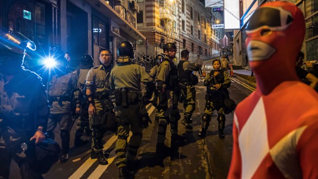 Riot police stand guard on the street during Halloween celebration.