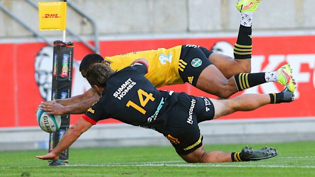 Julian Savea of the Hurricanes beats the tackle of Alex Nankivell of the Chiefs to score a try
