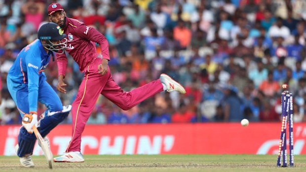 West Indies' Roston Chase, right, throws the ball to run-out India's Ravindra Jadeja