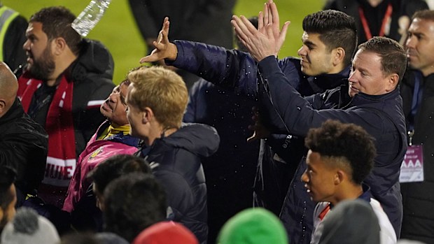 Mariners players and staff react as bottles are thrown at them by Hume City FC fans