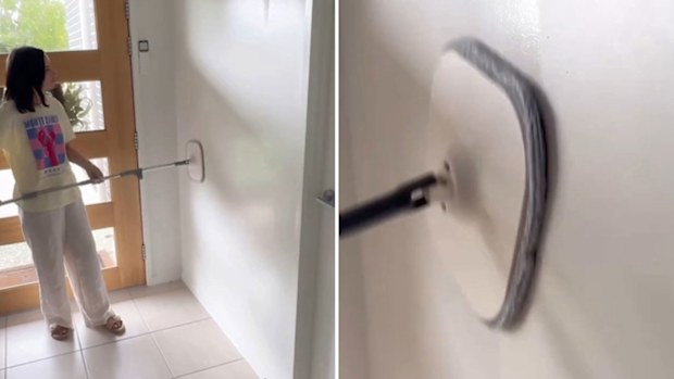 Corinne Mayfair mops her wall with the dual section spin mop set she purchased from Kmart