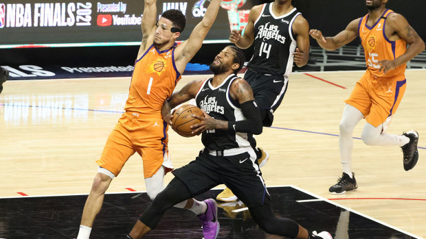 Paul George #13 of the LA Clippers drives to the basket against Devin Booker #1 of the Phoenix Suns during the second half of game three of the Western Conference Finals at Staples Center on June 24, 2021 in Los Angeles, California