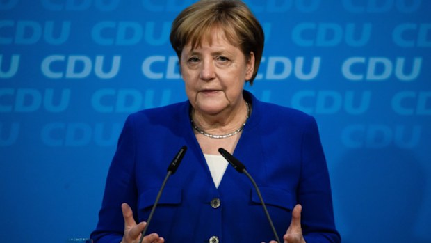 Angela Merkel has been urged to resolve a dispute over migrant policy with her interior minister.